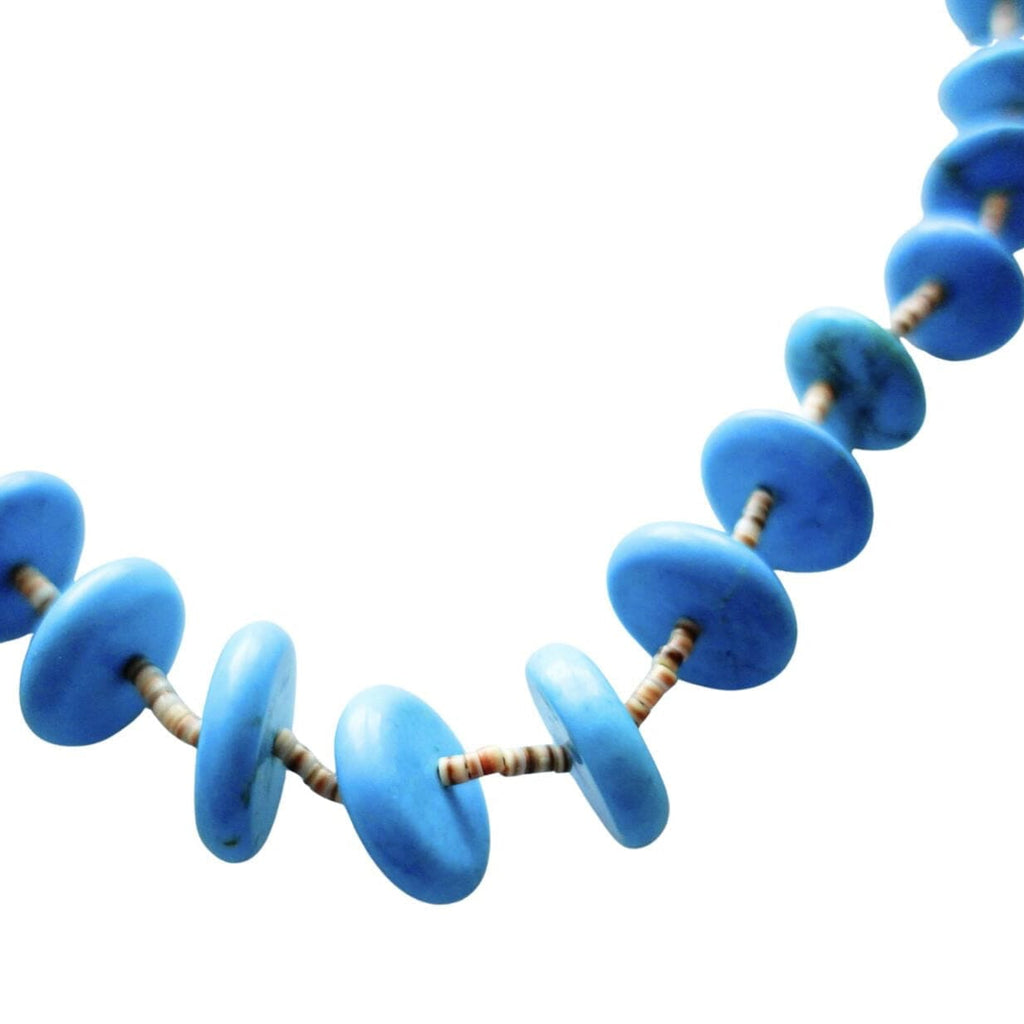 Macro close-up of bright blue round block turquoise beads, showcasing the vibrant color and texture of the Southwestern-style stones.