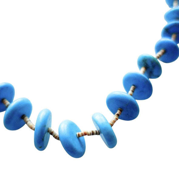 Macro close-up of bright blue round block turquoise beads, showcasing the vibrant color and texture of the Southwestern-style stones.