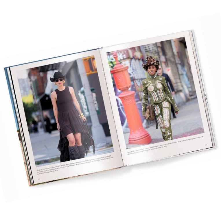 An open fashion book displayed on a white background, showing two full-page editorial photos. The left page features a model in a black dress and hat, and the right page shows a model in an ornate green and gold costume, with street scenes and small text below the images.