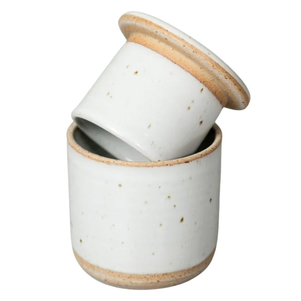 A small white ceramic lidded Butter Keeper with a matching lid resting on top, featuring subtle speckles and natural tan clay rims, set against a plain white background.