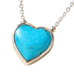 A heart-shaped turquoise pendant necklace in a silver bezel setting on a delicate silver chain, shown against a plain white background.