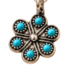 A five-petal flower pendant charm in an antique silver-tone metal, featuring five round turquoise blue cabochon stones set in each petal, with a central silver-tone stone and a bail at the top.