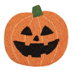 A circular beaded pumpkin trivet featuring a carved jack-o'-lantern face, with an orange body, black facial features, and a green stem, shown on a plain white background.