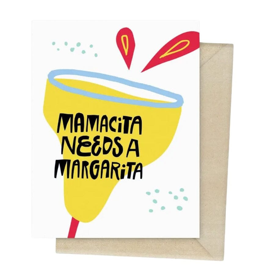 A square greeting card with a kraft envelope behind it, featuring a stylized yellow margarita glass with the text 'MAMACITA NEEDS A MARGARITA' in black lettering. The card has a white background with small blue dots and red and yellow graphic accents.