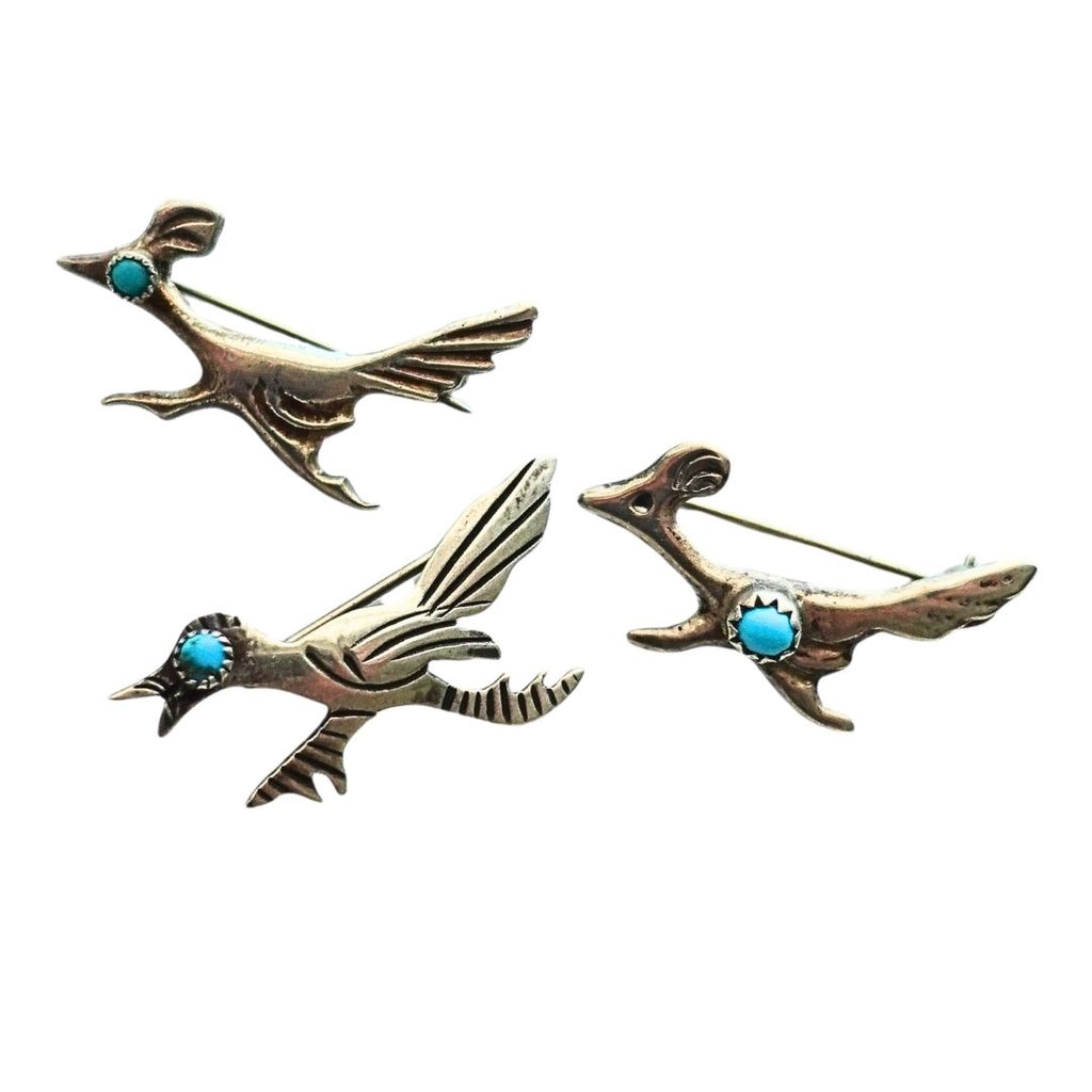 Three Roadrunner pins in sterling silver with small round turquoise stone accents, arranged on a plain white background.