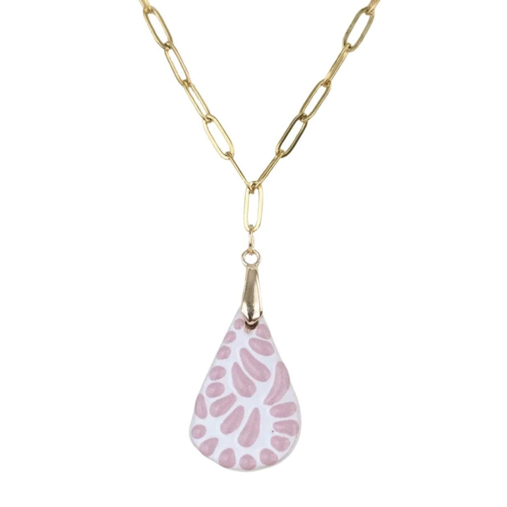 A gold paperclip chain necklace with a teardrop-shaped pendant featuring a pink and white spotted pattern, shown against a plain white background.