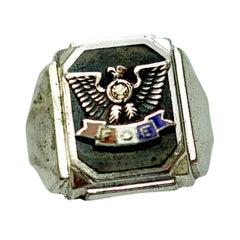 A silver-toned signet ring featuring a black enamel face with a gold-toned eagle emblem and a small multicolor 'FOR' banner, shown on a plain white background.