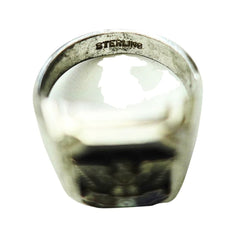 A sterling silver signet ring with a wide, polished band and a dark, engraved face, shown on a plain white background.
