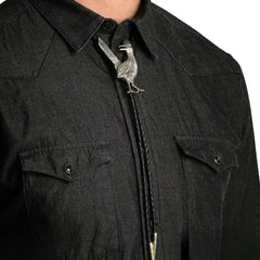 Close-up of a person wearing a black western-style collared shirt with a silver roadrunner bolo tie