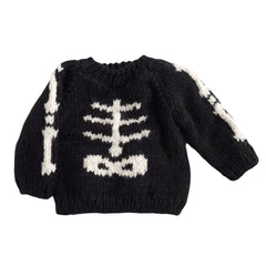 A black knit kids sweater featuring a white knitted skeleton rib cage pattern on the front and down the sleeves, shown against a plain white background.