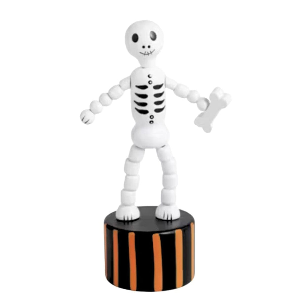 A white articulated skeleton toy figurine holding a small white bone, standing on a black cylindrical base with orange vertical stripes, isolated on a white background.