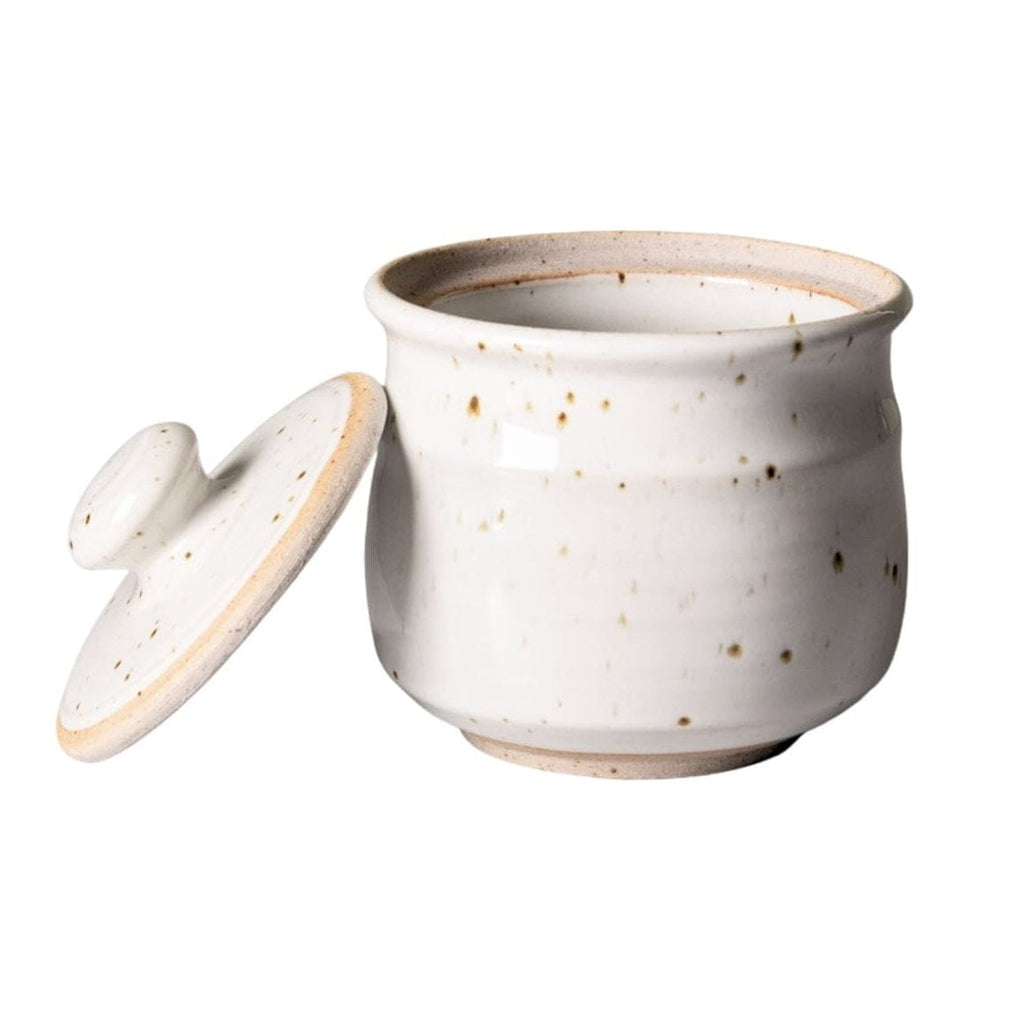 A small ceramic Sugar jar with a matching lid, featuring a speckled off-white glaze with subtle brown and beige tones, set against a plain white background.
