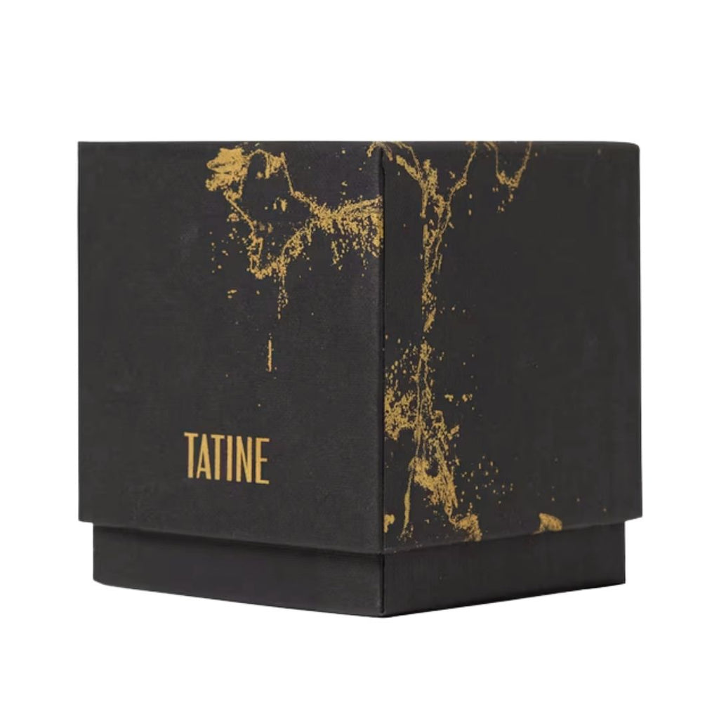 A black square product box with a gold metallic splatter pattern and the brand name 'TATINE' printed in gold on the front, set against a plain white background.
