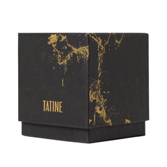 A black square product box with a gold metallic splatter pattern and the brand name 'TATINE' printed in gold on the front, set against a plain white background.