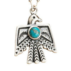A silver-toned raven pendant necklace featuring a round turquoise stone set in the center, suspended from a matching silver chain against a plain white background.