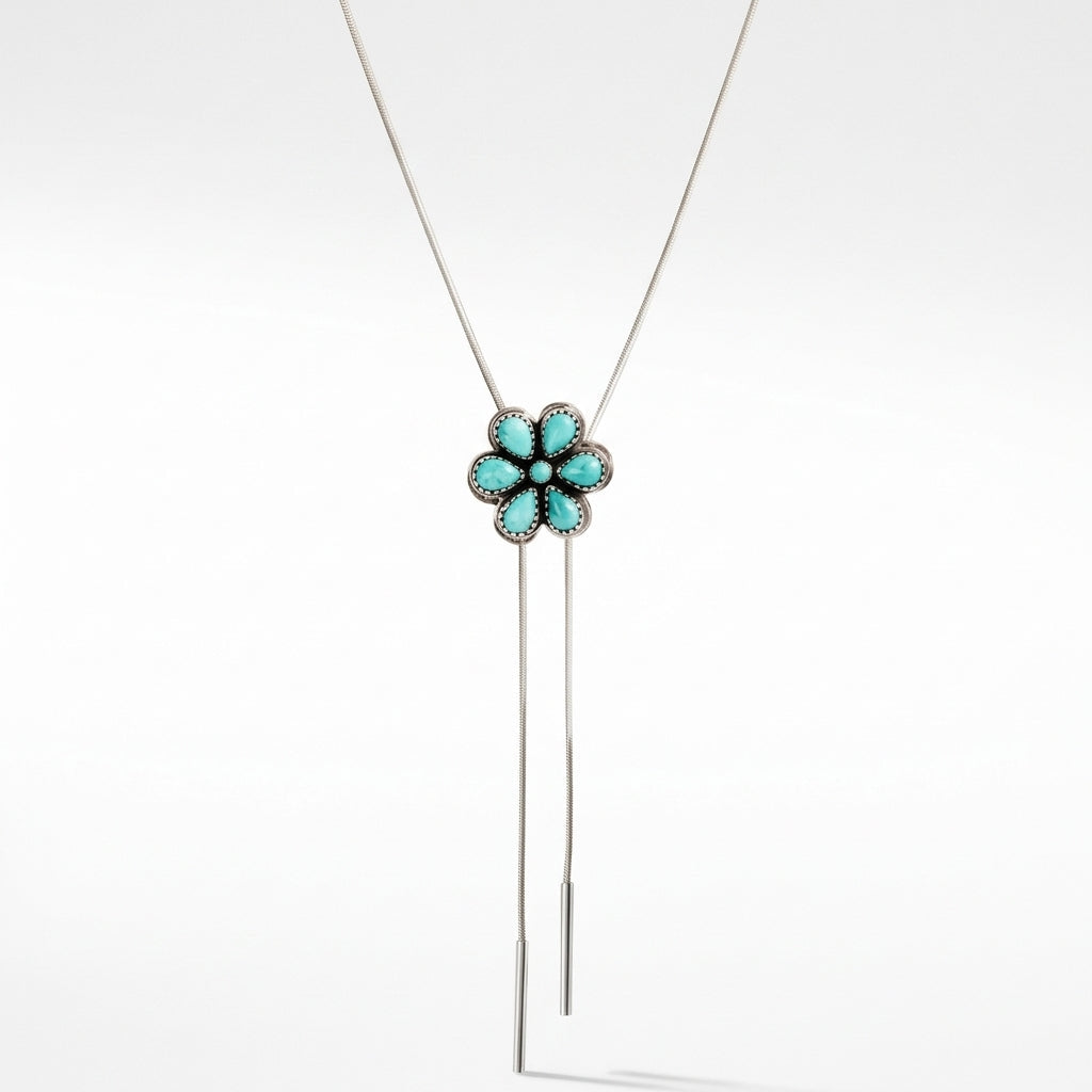 A silver lariat bolo necklace featuring a flower-shaped pendant with turquoise-colored stones and a long sterling snake chain, shown against a plain white background.