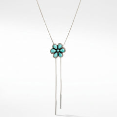 A silver lariat bolo necklace featuring a flower-shaped pendant with turquoise-colored stones and a long sterling snake chain, shown against a plain white background.