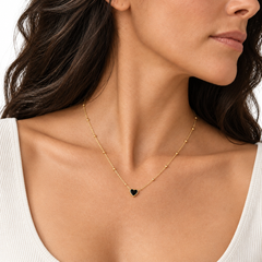 Woman wearing the black onyx heart necklace on a white background